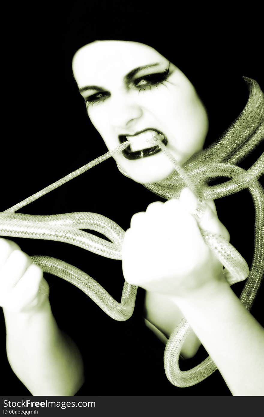 Young woman in goth make-up holding metal cord. Young woman in goth make-up holding metal cord.