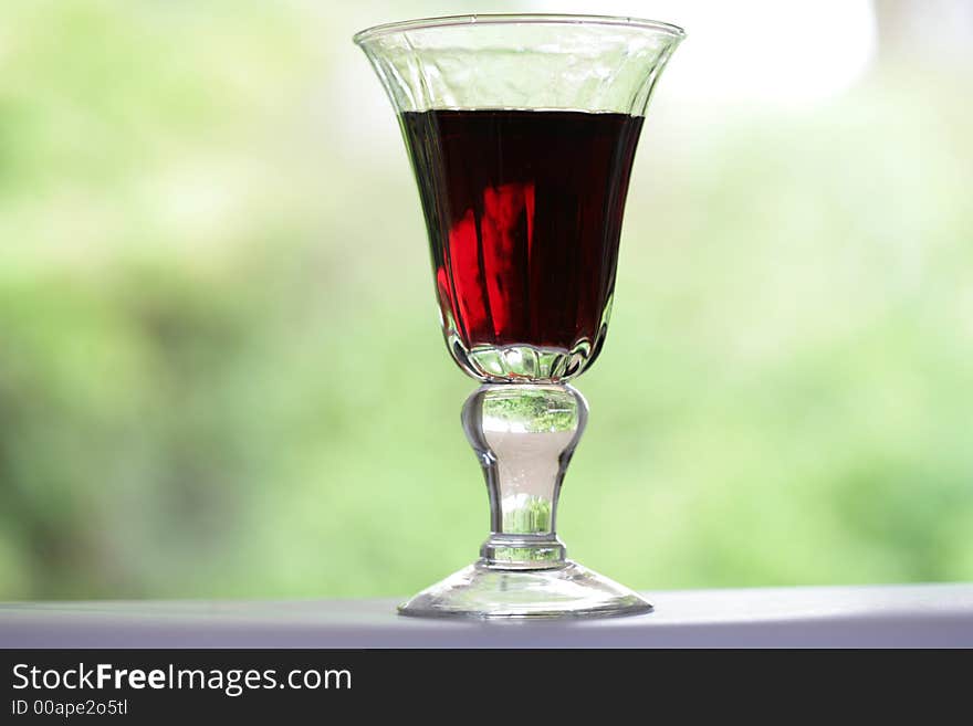 Red wine glass with green background