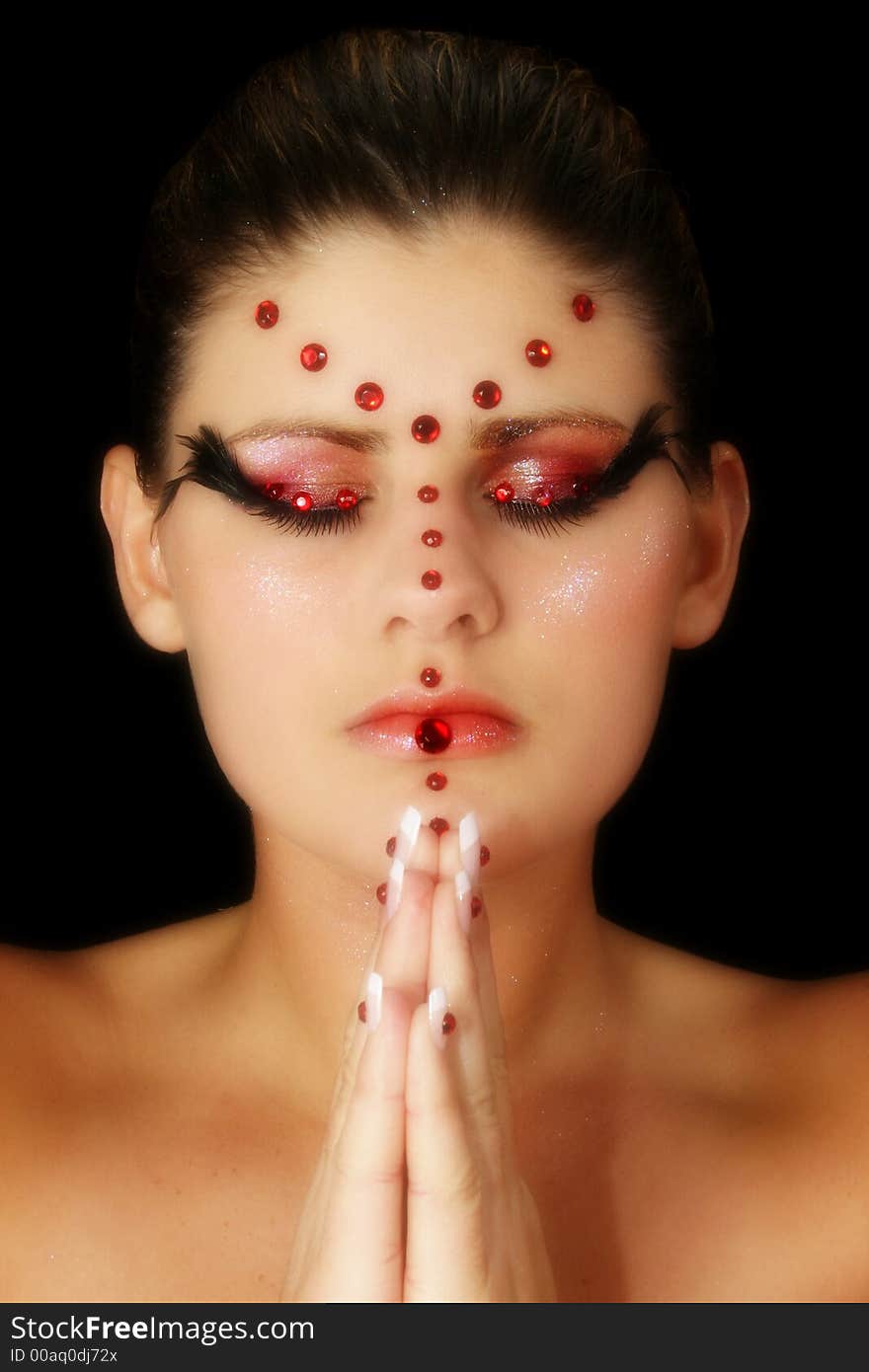 Beautiful young woman in artistic make-up and beads. Praying. Beautiful young woman in artistic make-up and beads. Praying.