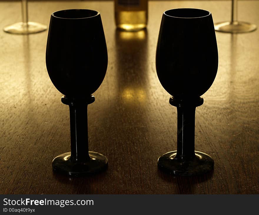 2 black winecups with bottle of white wine in the background