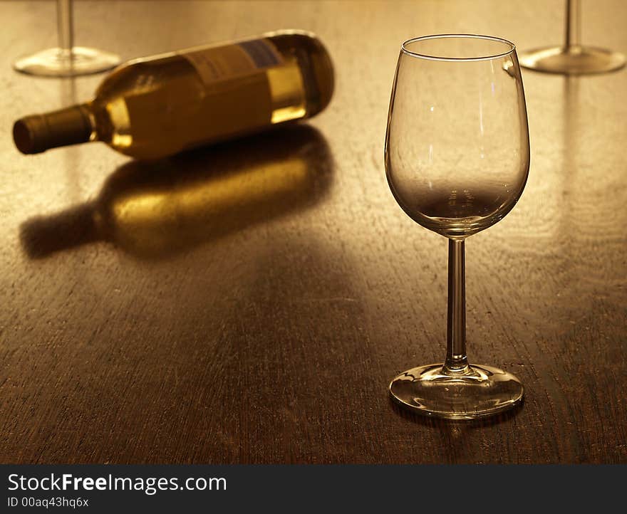 Empty glass with bottle of white wine in the background