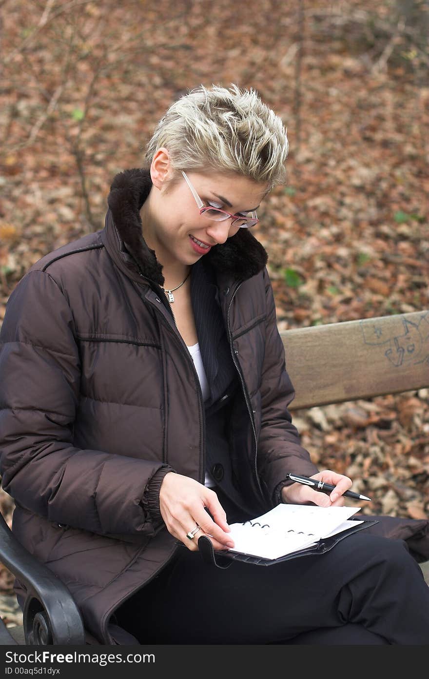 Business woman outdoor in a park reading mails and notebook