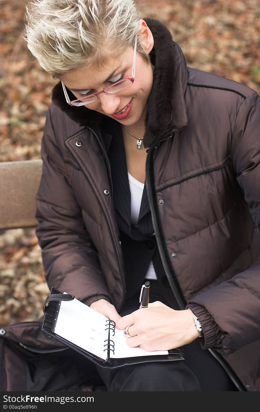 Business woman outdoor in a park reading mails and notebook