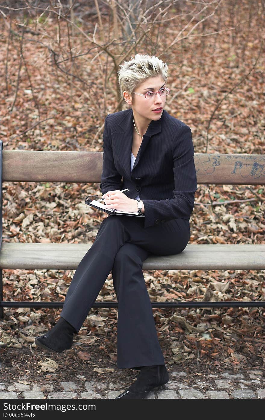 Business woman outdooring a park reading mails and notebook. Business woman outdooring a park reading mails and notebook