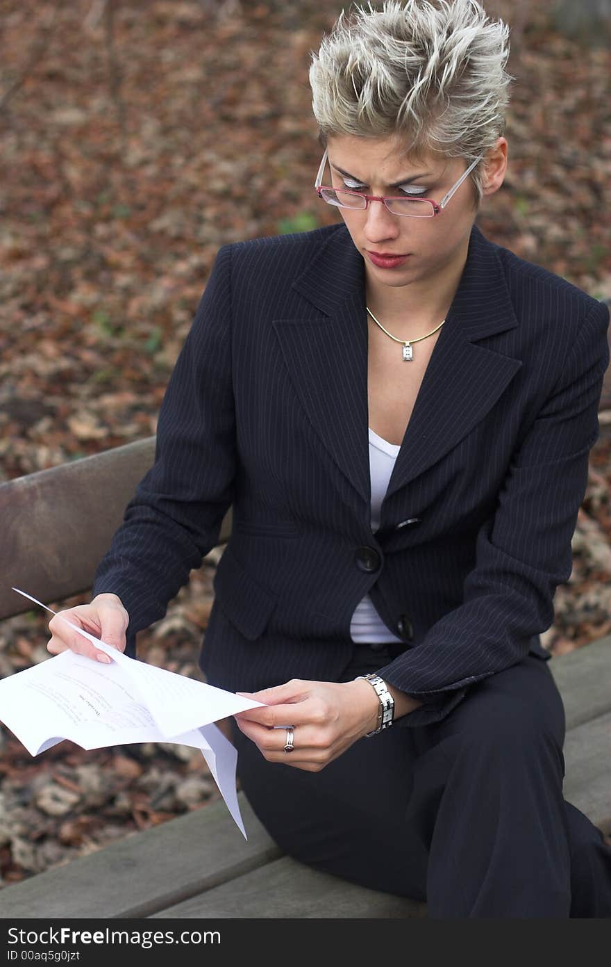 Business woman outdoor in a park reading mails and notebook