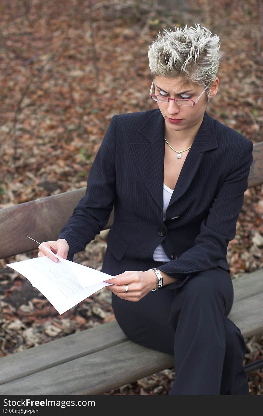 Business woman outdoor in a park reading mails and notebook