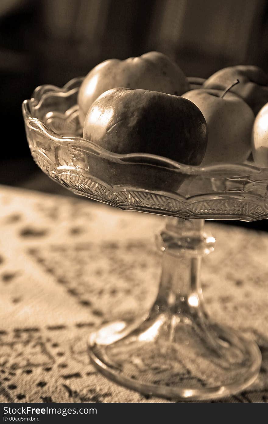 Some apples in sepia colors in a glass bowl
