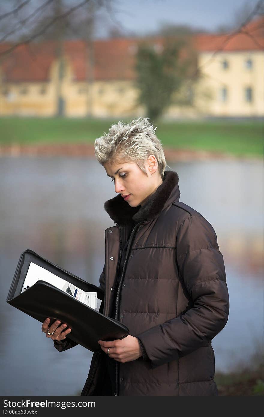 Business woman outdooring a park reading mails and notebook. Business woman outdooring a park reading mails and notebook