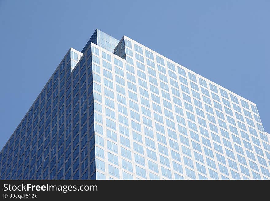 Geometrical skyscraper rises in the cloudless sky