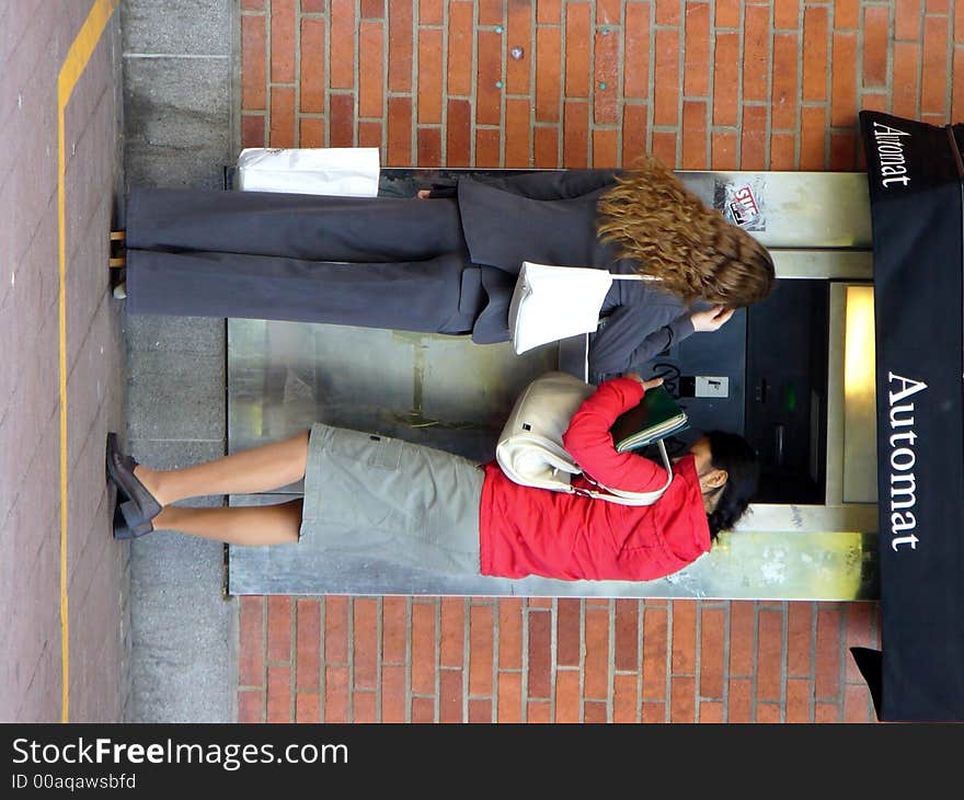 Two girls by the money-automat. Two girls by the money-automat.