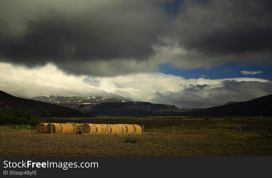 Sunlit straw bales in a meadow, Iceland