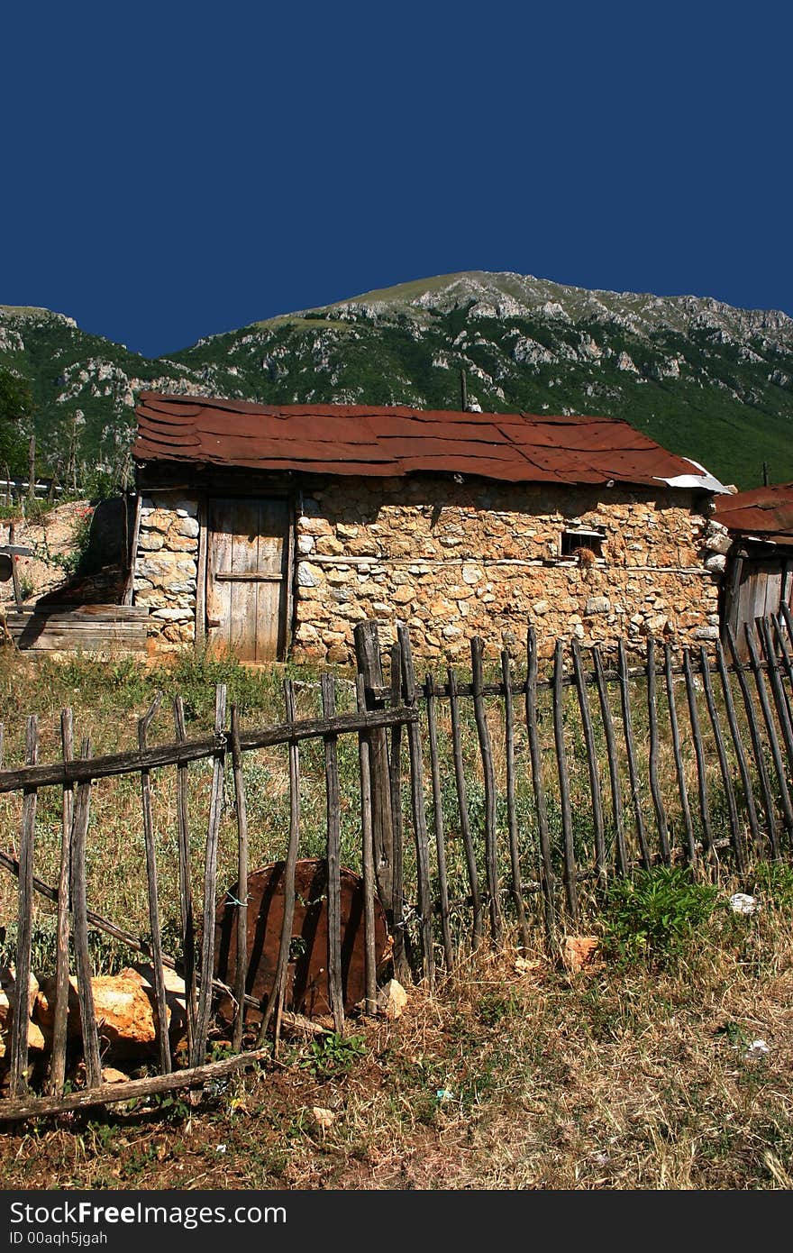 Old abandoned house with wooden fence in foreground