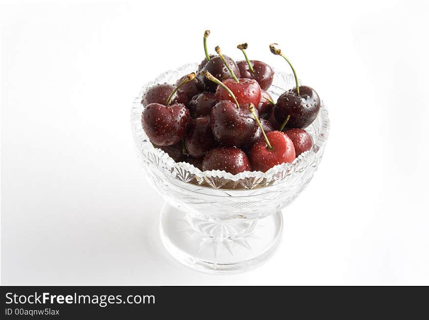 Fresh red cherries in a crystal bowl on white background. Fresh red cherries in a crystal bowl on white background