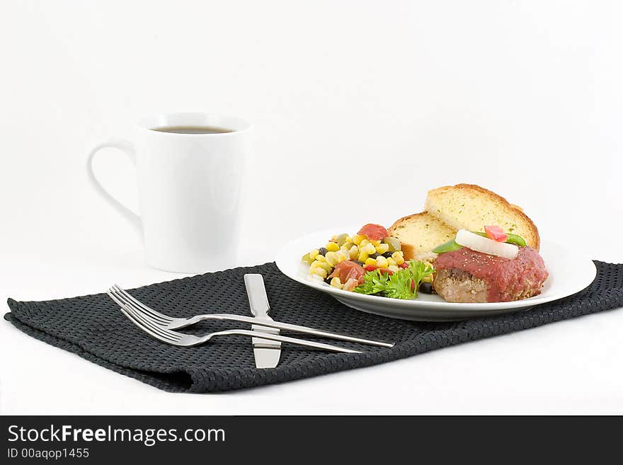 Ground turkey patty topped with seasoned tomato sauce and garnished with red and green pepper and onion, accompanied by a season corn,black bean and pepper vegetable, garlic bread and coffee.