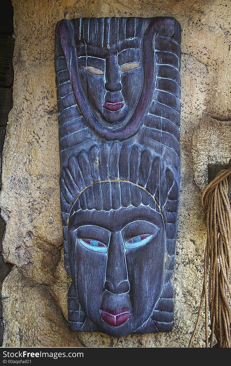 Traditional african mask hanging on grunge stone wall