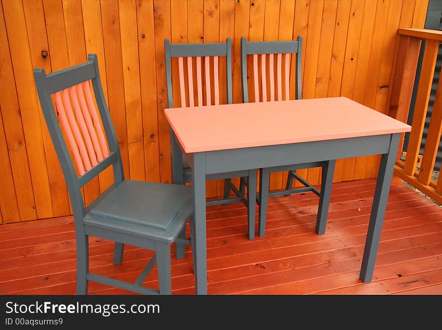 A table and chairs setting on a wooden deck. Photographer: Crystal Venus. A table and chairs setting on a wooden deck. Photographer: Crystal Venus.