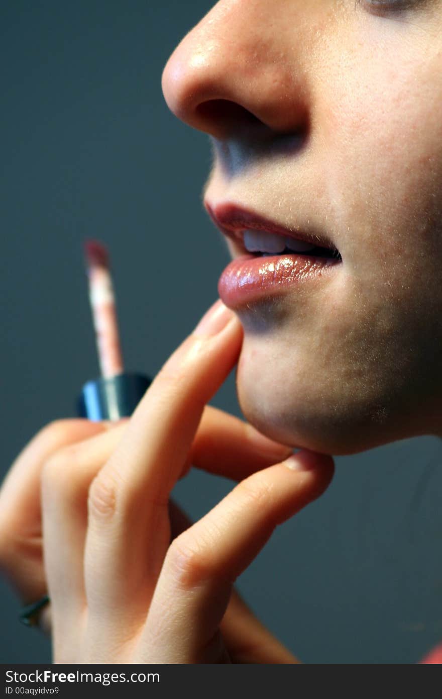 Woman correcting lip contour applying lip gloss. Woman correcting lip contour applying lip gloss