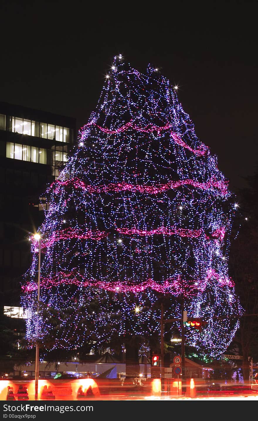 Festive decorated tree during a street illumination festival in Sendai.In the bottom of the image there is a motion blur generated by the traffic.