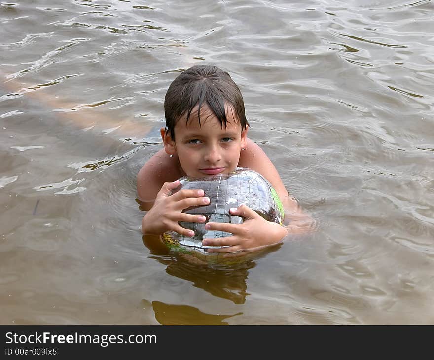 Boy with plastic transparent toy ball globe in water. Boy with plastic transparent toy ball globe in water