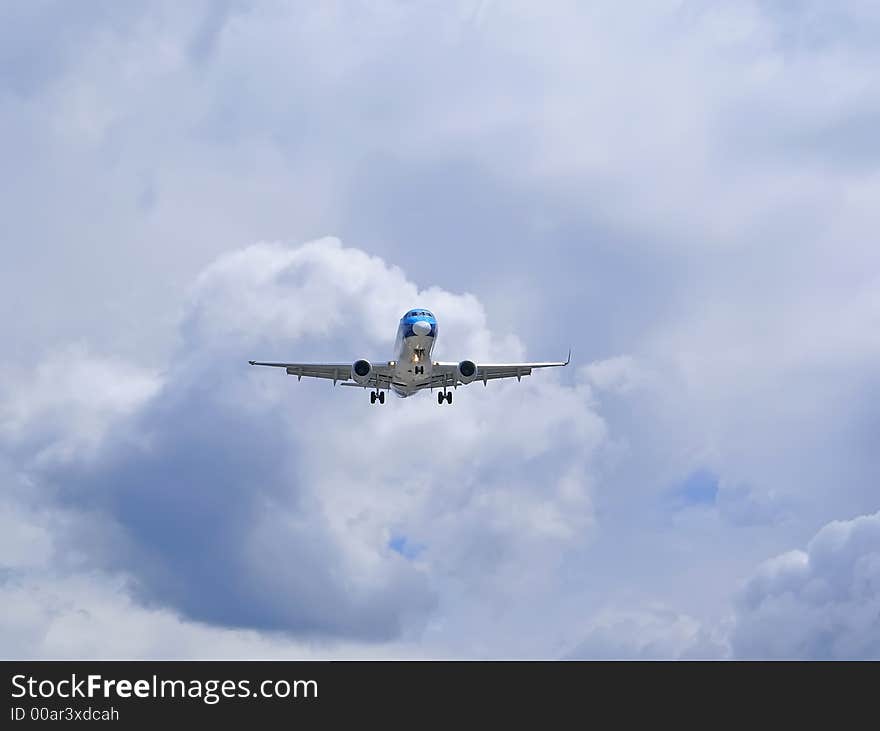 Passenger airplane on the grey cloudy sky