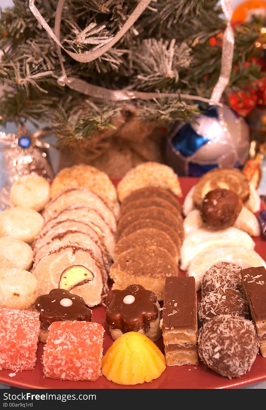 Christmas cookies in a red plate on a table. Christmas cookies in a red plate on a table