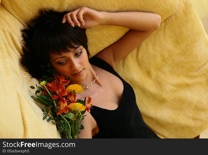 Young girl with flowers laying on a sofa