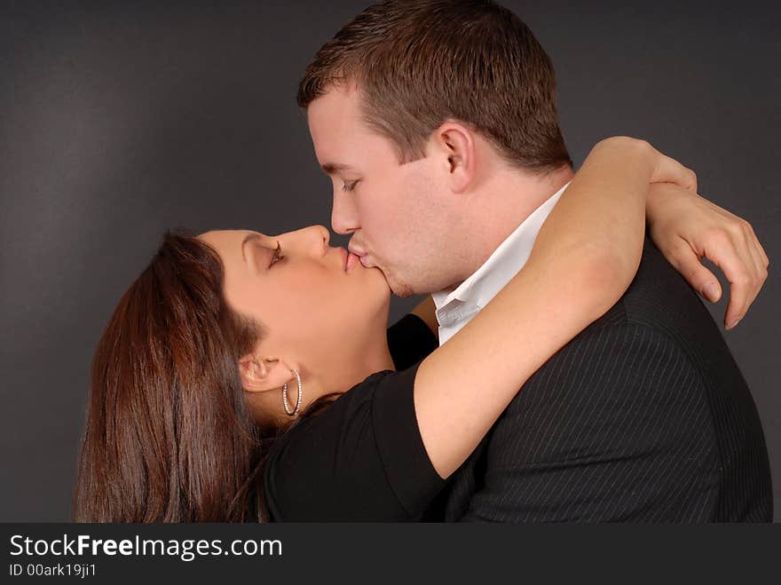 Attractive young couple in each others arms kissing