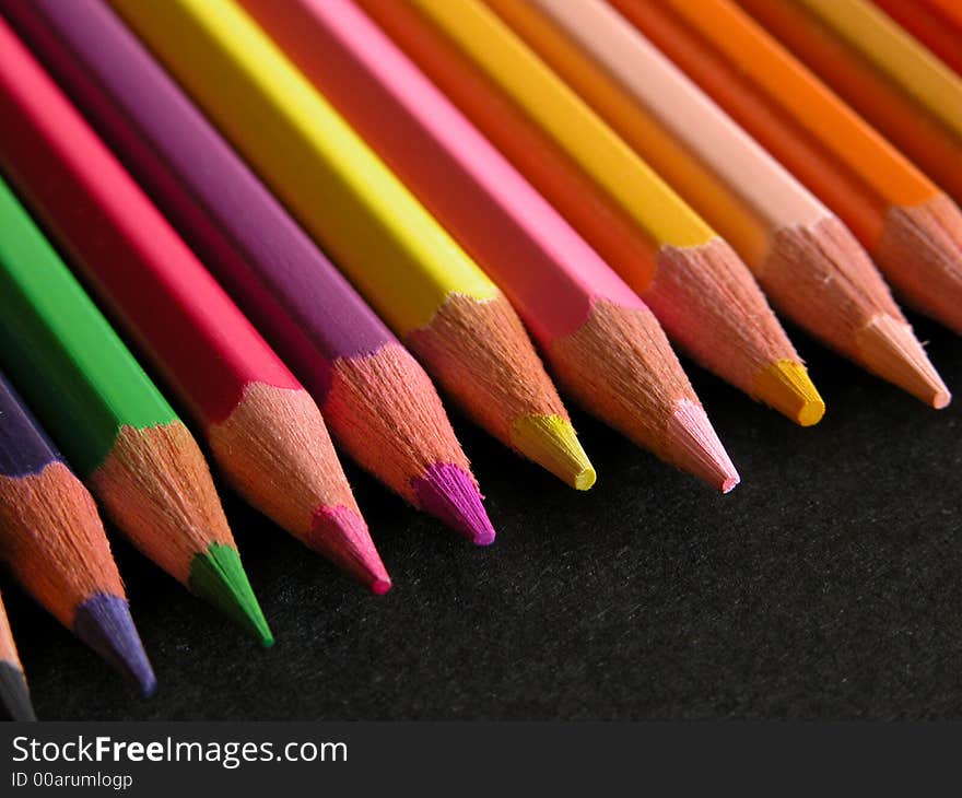 Color pencils isolated on black background.