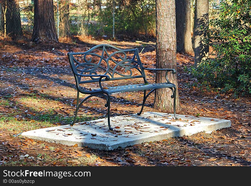 Wrought iron bench in park on winter day. Wrought iron bench in park on winter day