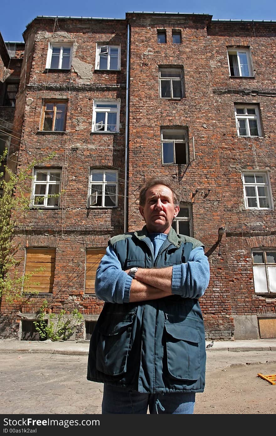 Man in front of ruined house