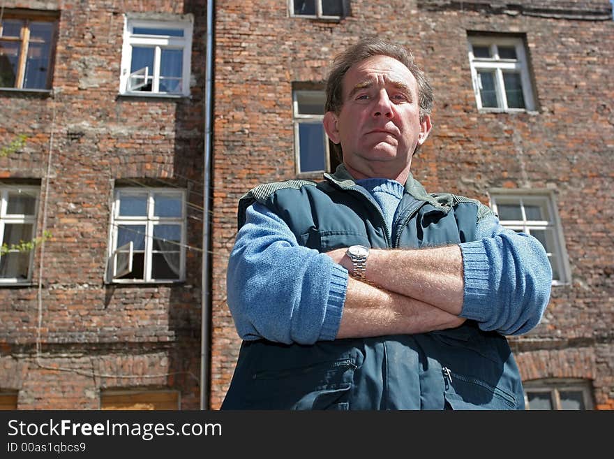 Man in front of ruined house