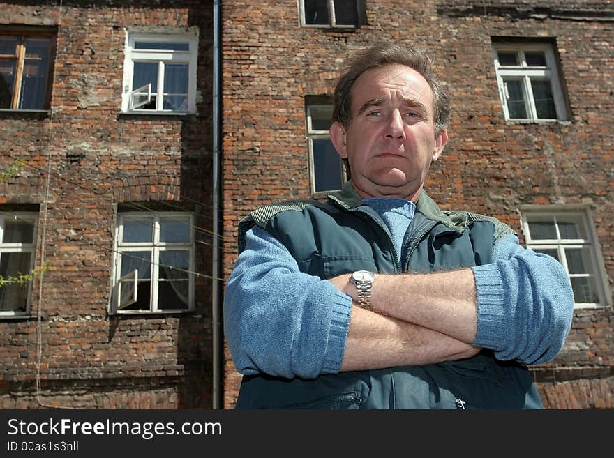 Man in front of ruined house