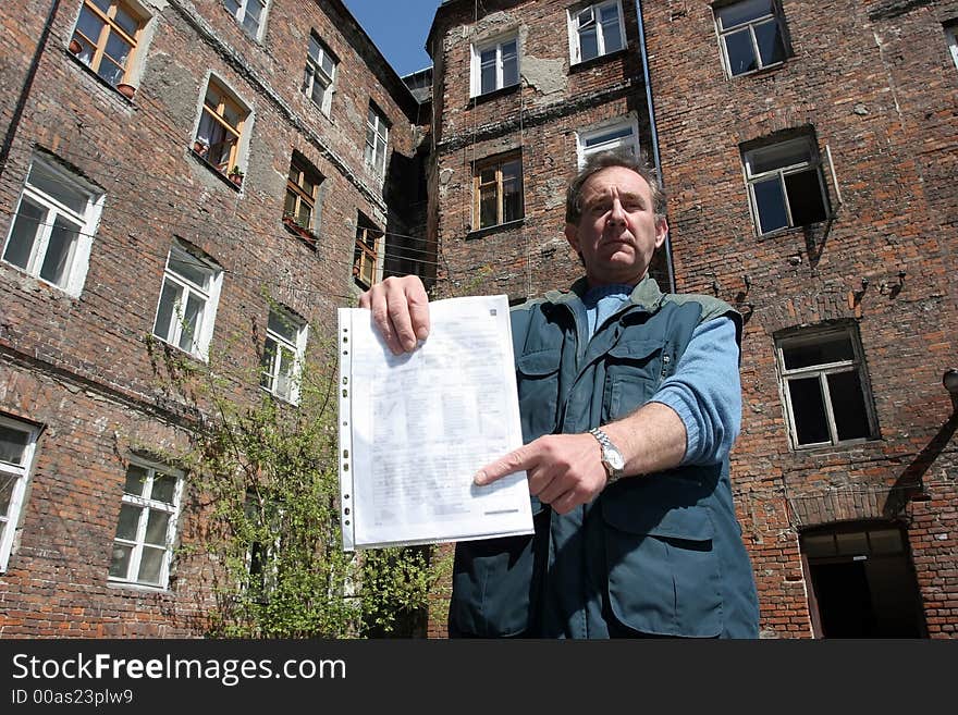 Man In Front Of Ruined House