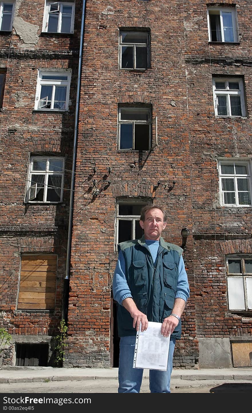 Man in front of ruined house