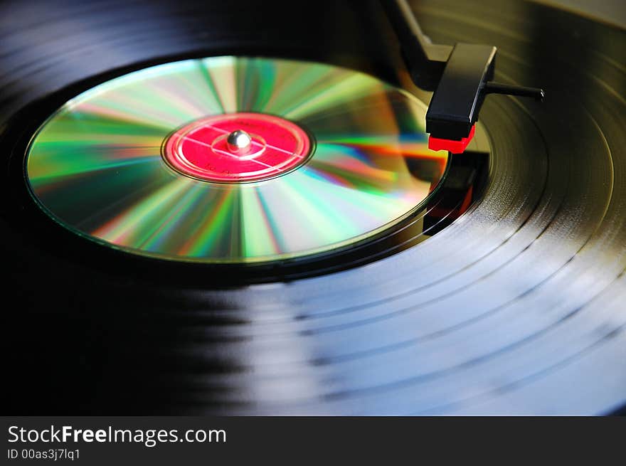 Abstract photo of Vinyl record compared against new technology-Compact Disc on a turn table.