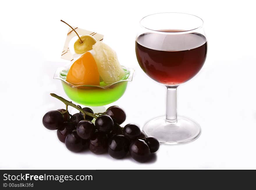 Close up of red wine with grapes and dessert.