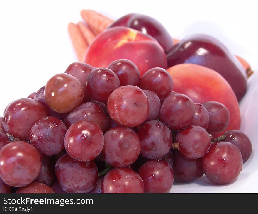 A bunch of fruit and vegetable, including, carrot, apple, apricot and grapes