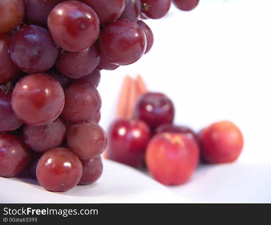 A bunch of fruit and vegetable, including, carrot, apple, apricot and grapes