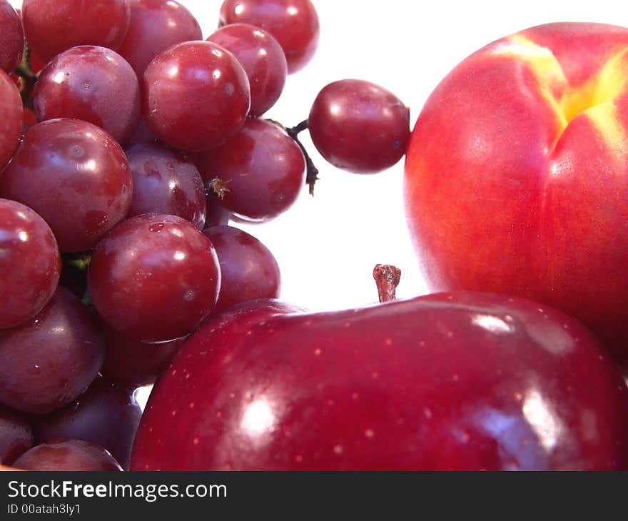 A bunch of fruit, including, apple, apricot and grapes