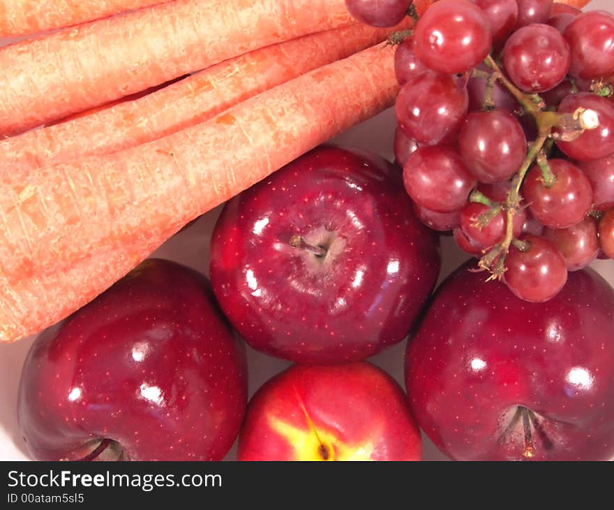 A bunch of fruit and vegetable, including, carrot, apple, apricot and grapes