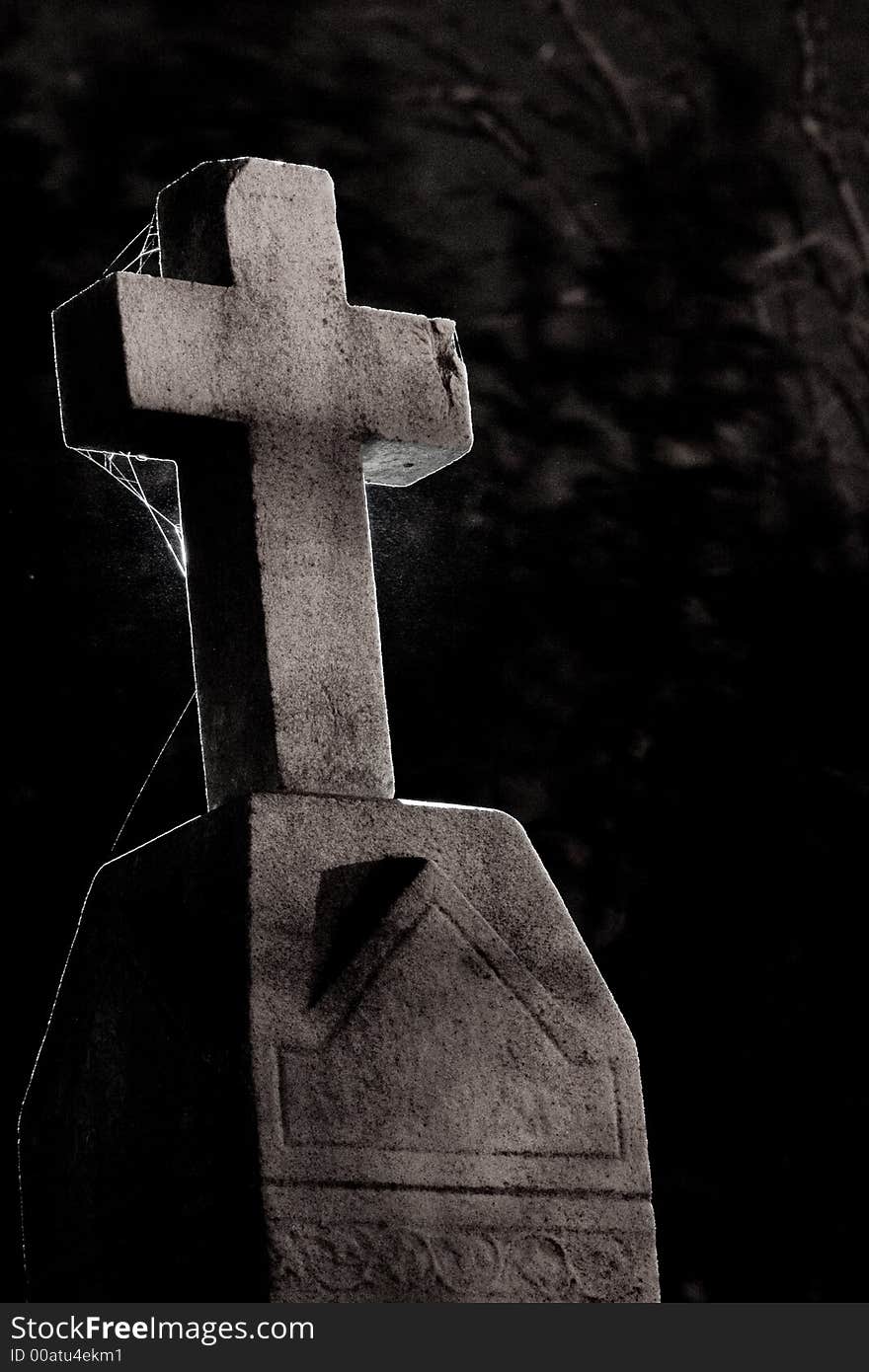 A cross on a tombstone, backlight with a hot shoe flash. A cross on a tombstone, backlight with a hot shoe flash.