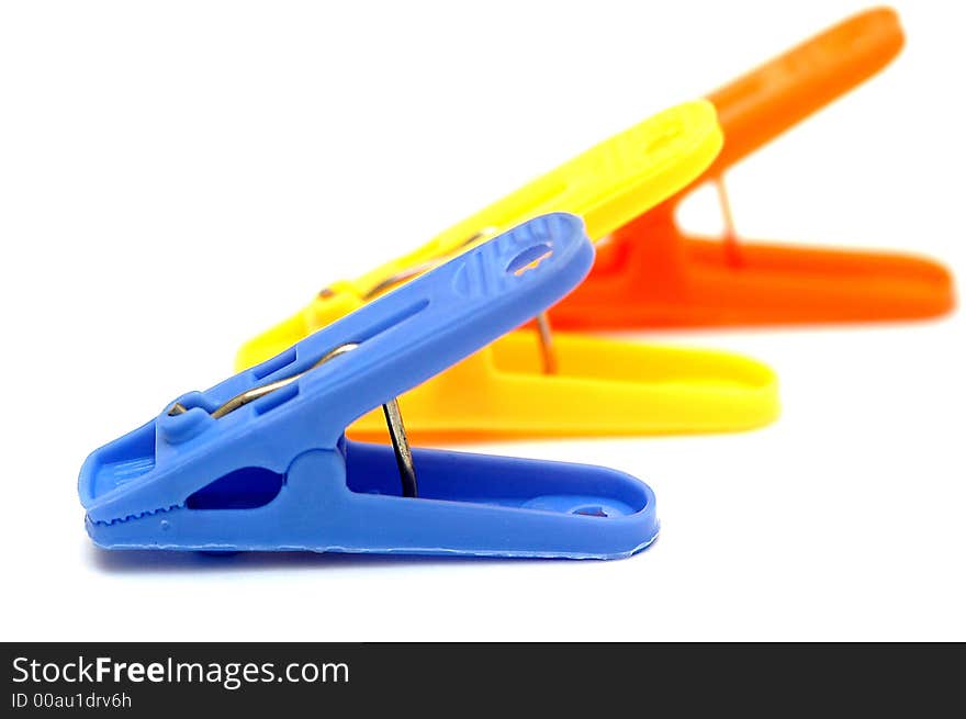 3 colorful clothespins with white background. Blue, yellow and orange.