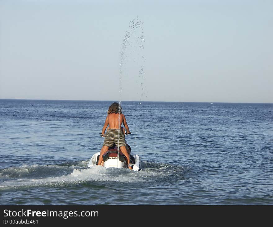 Young guy riding a jet ski. Young guy riding a jet ski