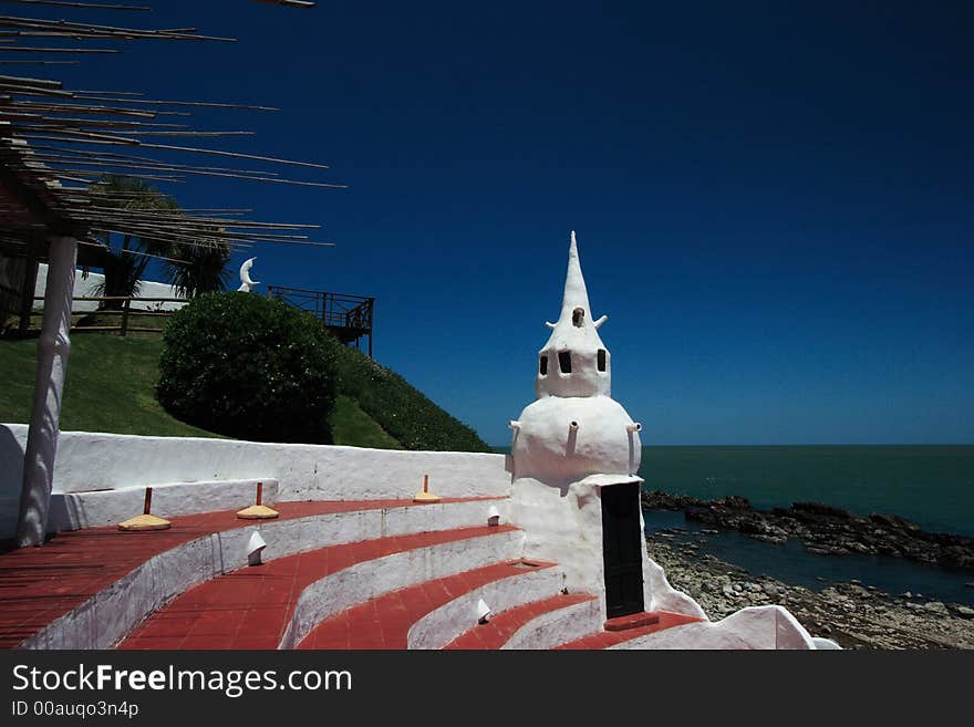 Casapueblo is the definitive tourist symbol of Punta del Este and one of the most popular resorts in all of Uruguay. The versatile Uruguayan artist, Carlos Paez Vilaró, created Casapueblo. His main objective was to create a sculpture in which he could actually live, where he would have the chance to paint in artistic surroundings and yet be able to socialize with friends. Casapueblo is the definitive tourist symbol of Punta del Este and one of the most popular resorts in all of Uruguay. The versatile Uruguayan artist, Carlos Paez Vilaró, created Casapueblo. His main objective was to create a sculpture in which he could actually live, where he would have the chance to paint in artistic surroundings and yet be able to socialize with friends.