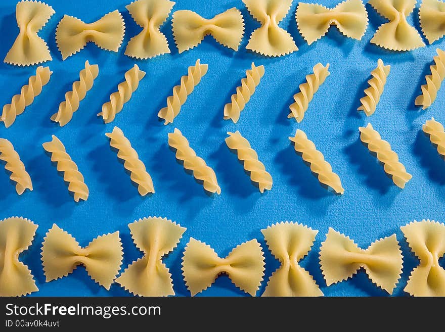 Various types of pasta on blue paper