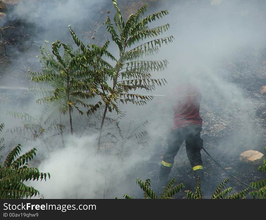 A firemaker works inside smoke. A firemaker works inside smoke