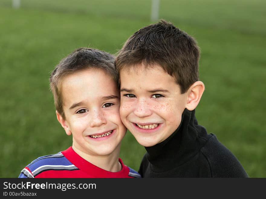 Brothers smiling with green grass background