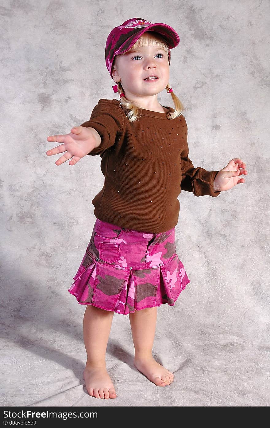 A cute little girl posing on a gray background. A cute little girl posing on a gray background.