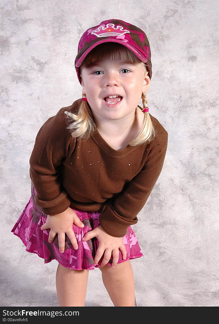 A cute little girl posing on a gray background. A cute little girl posing on a gray background.