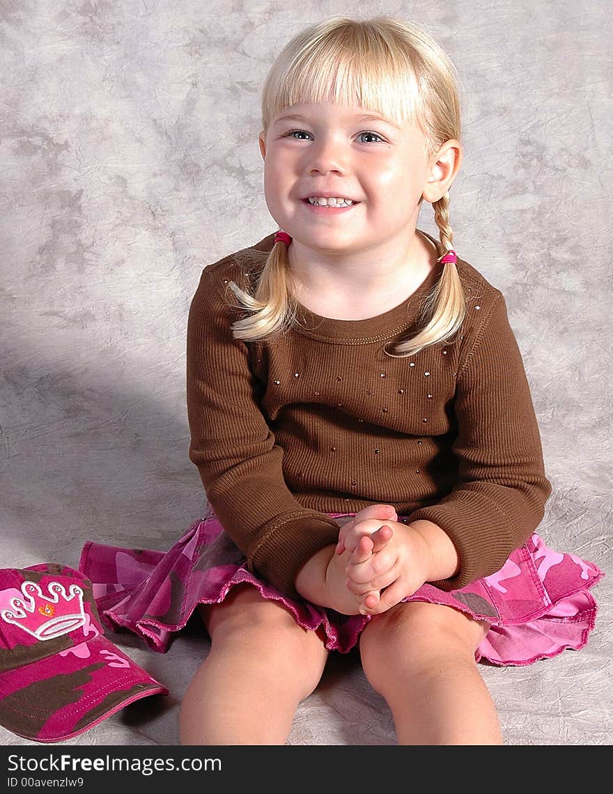 A cute little girl posing on a gray background. A cute little girl posing on a gray background.